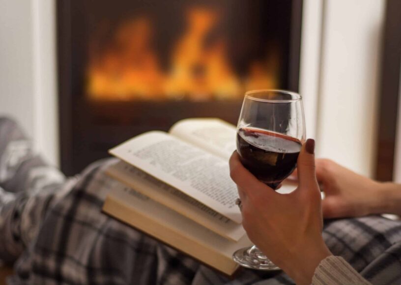 Woman,Reading,Book,And,Drinking,Red,Wine,In,Front,Of